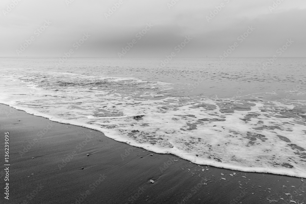 Obraz premium The sea washes the beach. Black and white photo shows a beautiful abstract atmosphere.