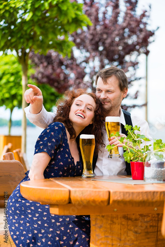 Man and woman sitting in beer garden pub © Kzenon