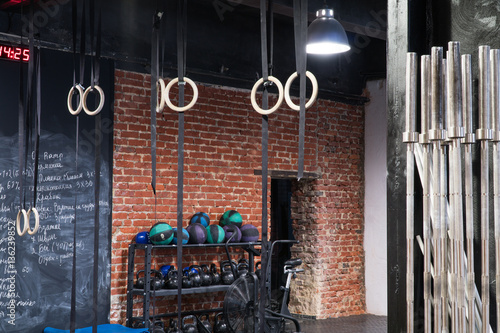 Contemporary interior of a cross-fit gym, red brick wall with sport equipment
