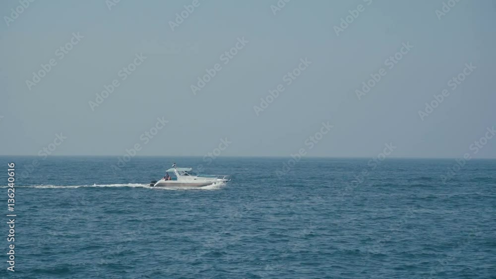 Water craft - boat - moves from left to right. View from the sea shore: the waves and the boat. Shipping. Tropical exotic destination, sail ship cruise ski jet, ocean view idyllic Paradise island Water craft - boat - moves from left to right. View from the sea shore: the waves and the boat. Shipping. Tropical exotic destination, sail ship cruise ski jet, ocean view idyllic Paradise island