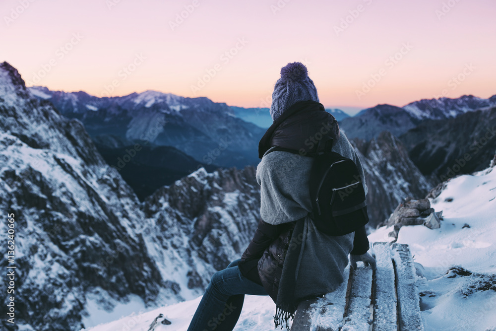 Rest, fresh air. Woman sitting and looking at winter mountain landscape