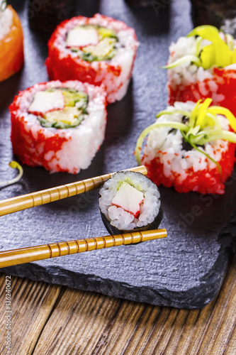 Close up of chopsticks taking a sushi roll