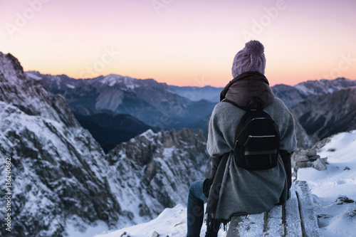 Rest, fresh air. Woman sitting and looking at winter mountain landscape