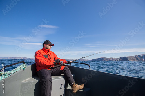 Fisherman fishing on athlete spinning with sea boats