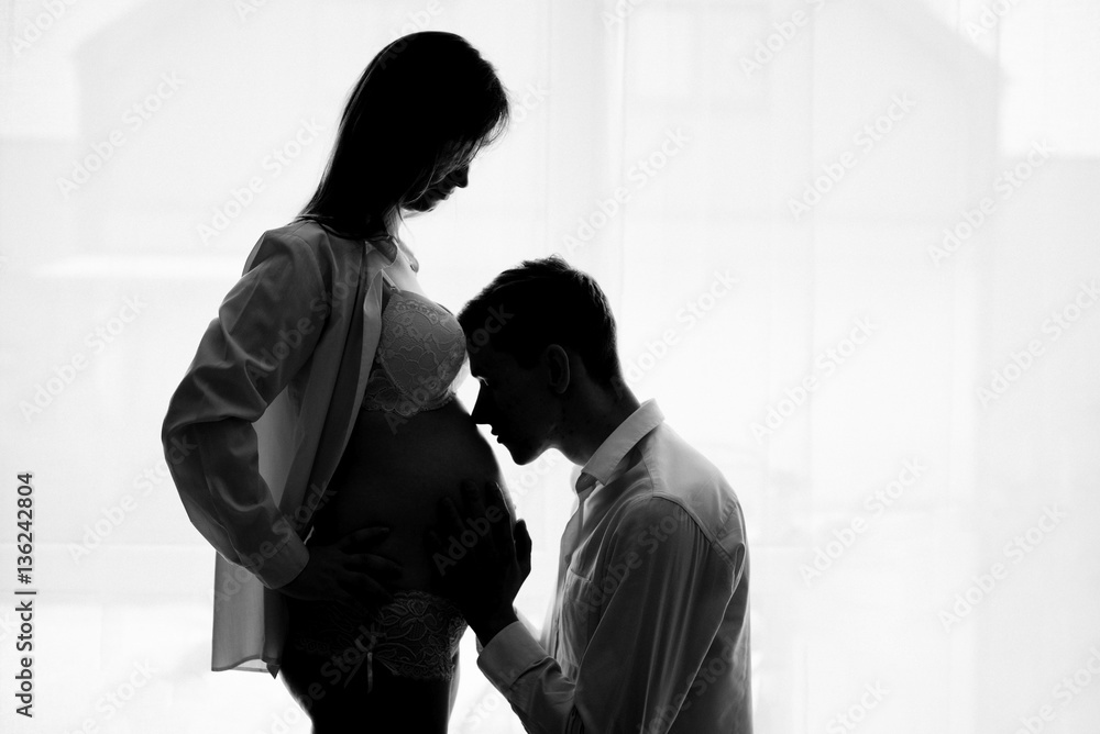 Husband is kissing pregnant wife's tummy