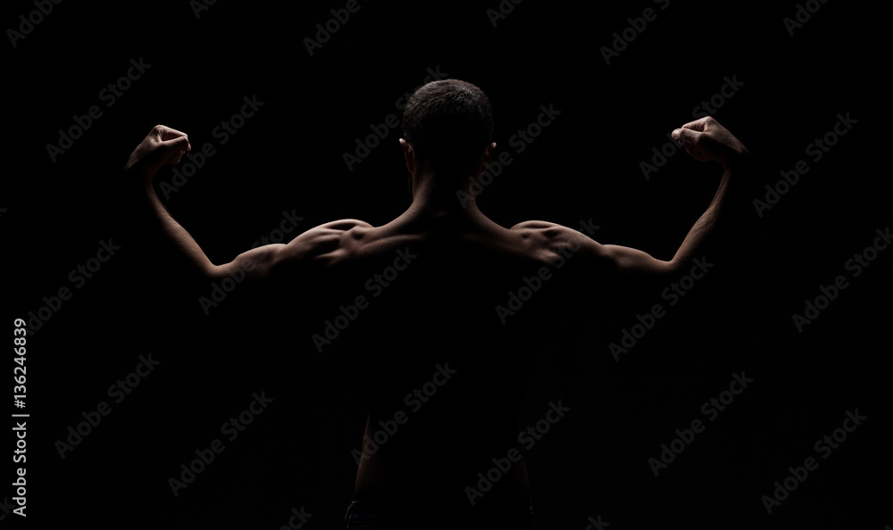 strong athletic mans back isolated on black background