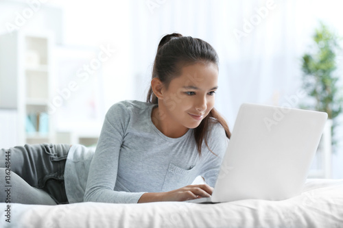 Cute girl lying on bed with...