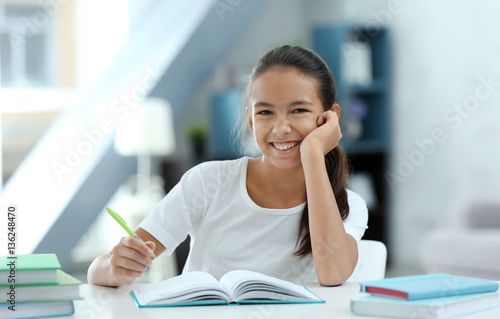 Cute girl doing lessons at home