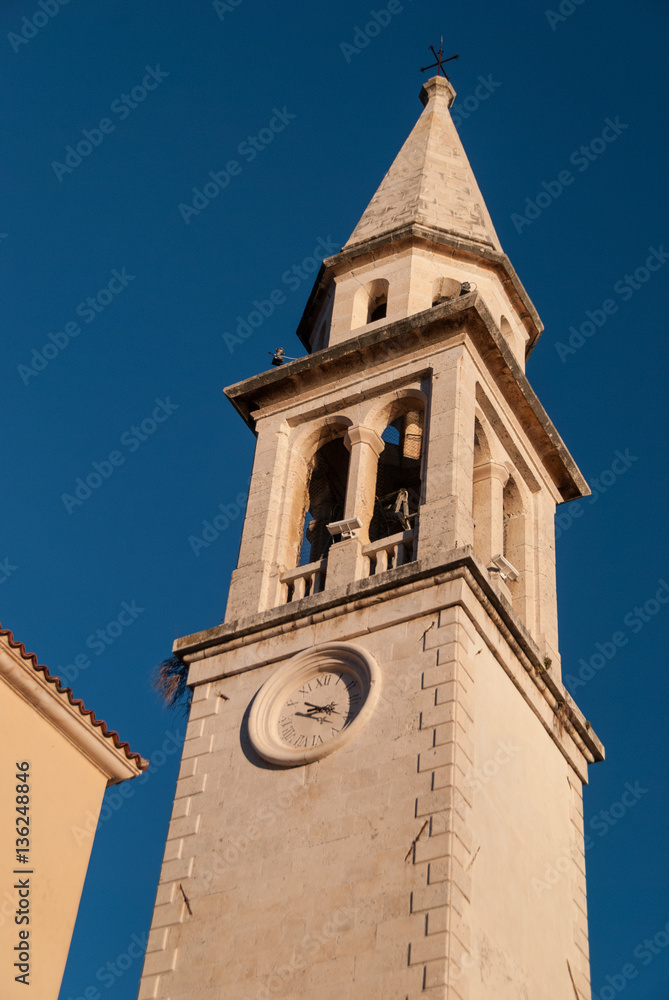 Fototapeta premium Ancient orthodox church bell tower in Budva old town with deep blue sky in the background
