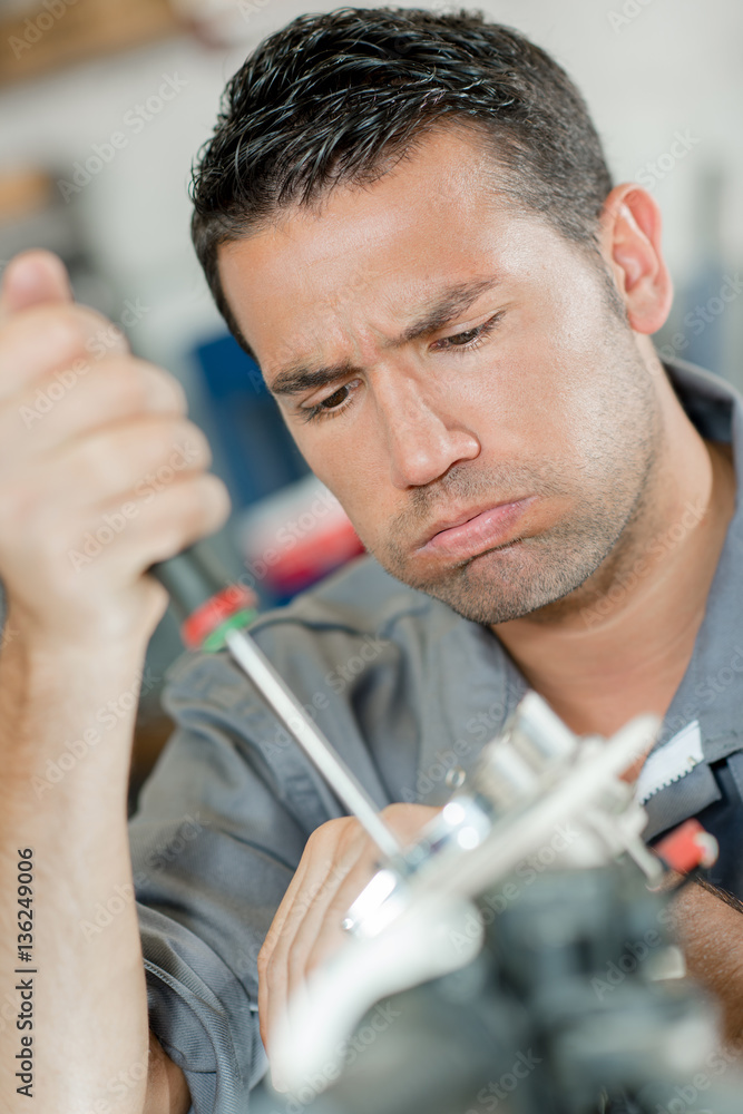Fototapeta premium Working mechanic, frustrated expression