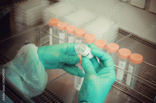 Lab technician takes sample from tube for test, close up photo