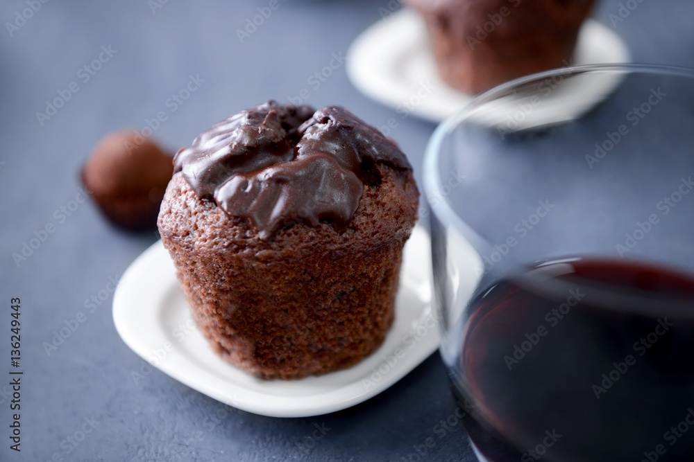 Delicious chocolate muffin and glass of red wine on grey table, close up Delicious chocolate muffin and glass of red wine on grey table, close up