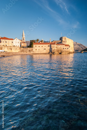 Ancient stone buildings by the sea at sunset in old town Budva, Montenegro