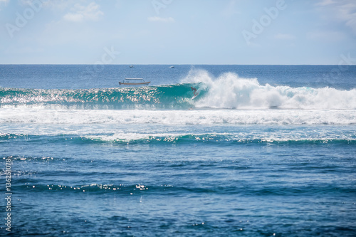 Tropical surfing on blue wave in Bali. Sunny day in paradise