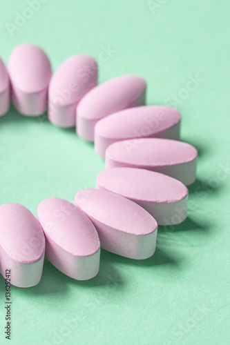 pink pills on green background