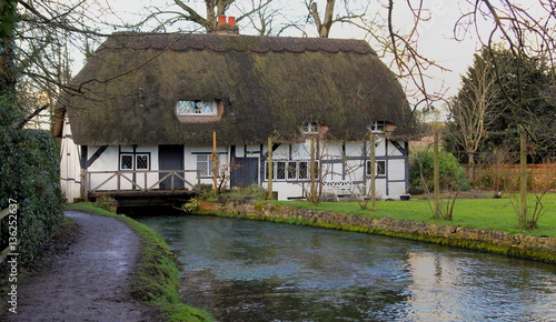 English mill cottage with Thatched roof built over a river