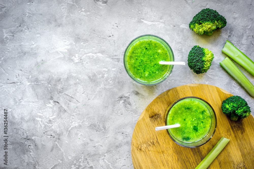 Green vegetable smoothie in glass at gray background top view Green vegetable smoothie in glass at gray background top view