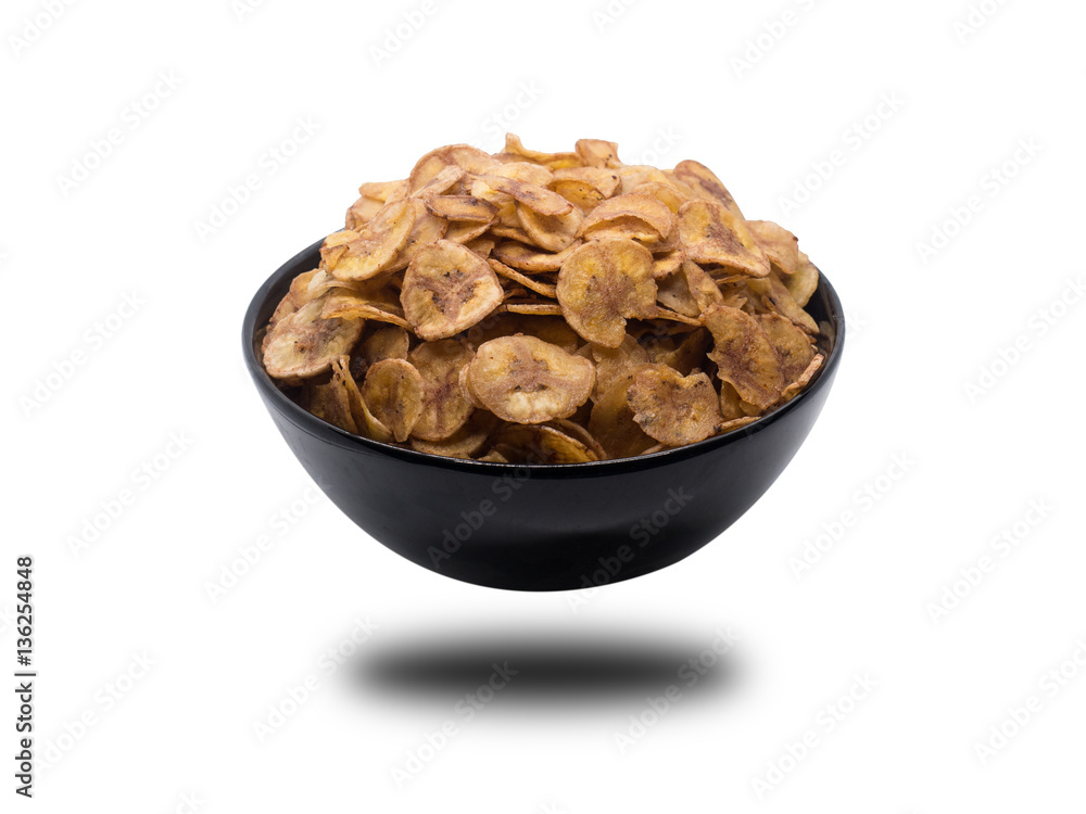 Sweet bananas chip in black bowl isolated on white background. S Sweet bananas chip in black bowl isolated on white background. S