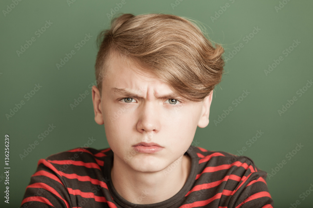 Petulant young teenage boy with a fierce scowl Petulant young teenage boy with a fierce scowl