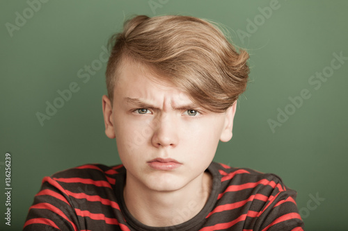 Foto Petulant young teenage boy with a fierce scowl