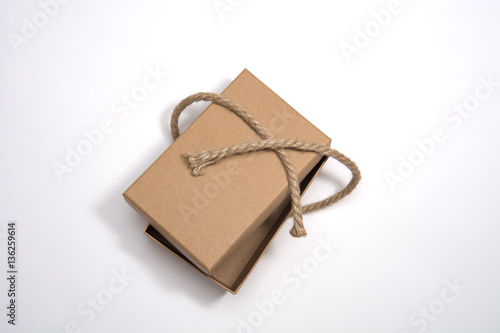 Rustic gift box on white background with space for text. Gift box packed recycled brown paper and twine. Concepts are holiday gift, eco friendly packing, rustic style gift wrapping.