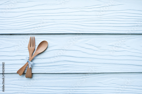 Wooden spoon and wooden fork on white wooden background.