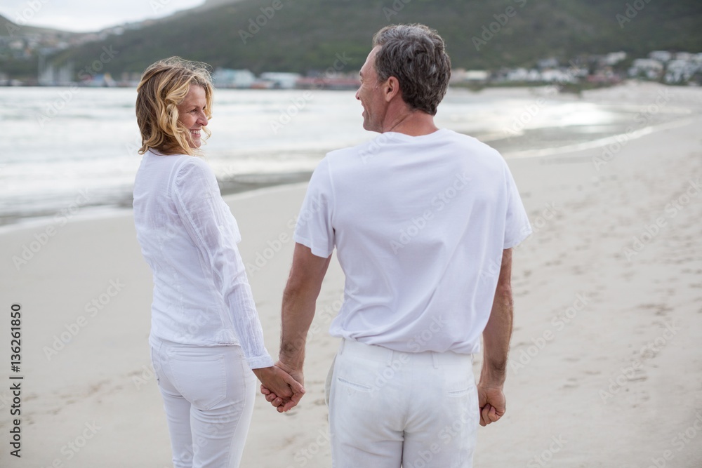 Couple standing with holding hands on the beach Couple standing with holding hands on the beach