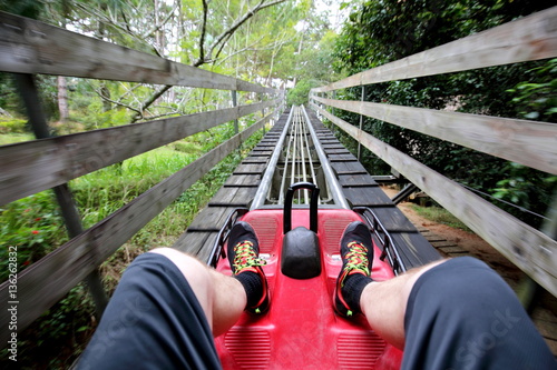 Rail downhill on a trolley to the Datanla waterfall in Vietnam. Foot passenger in sneakers on the trolley track 
