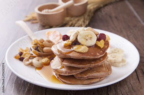 Sweet pancake with banana and serial topping on the wood table in morning light