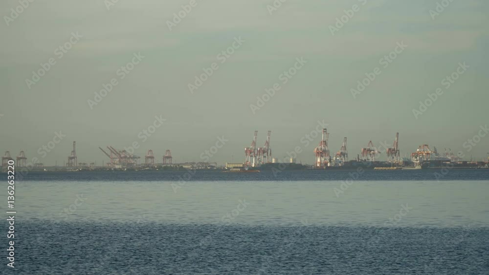 Industrial cargo port with ships and cranes. View of the cargo port and container terminal. Container cranes in Manila Bay. Cargo ship in industrial port. Manila, Philippines. 4K video. Industrial cargo port with ships and cranes. View of the cargo port and container terminal. Container cranes in Manila Bay. Cargo ship in industrial port. Manila, Philippines. 4K video.
