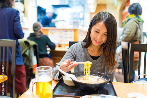 Woman eating japanese ramen in japanese restaurant