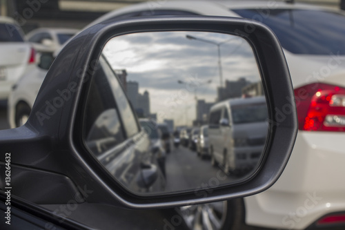 The side view mirror shows many cars get the traffic jam. © oppos