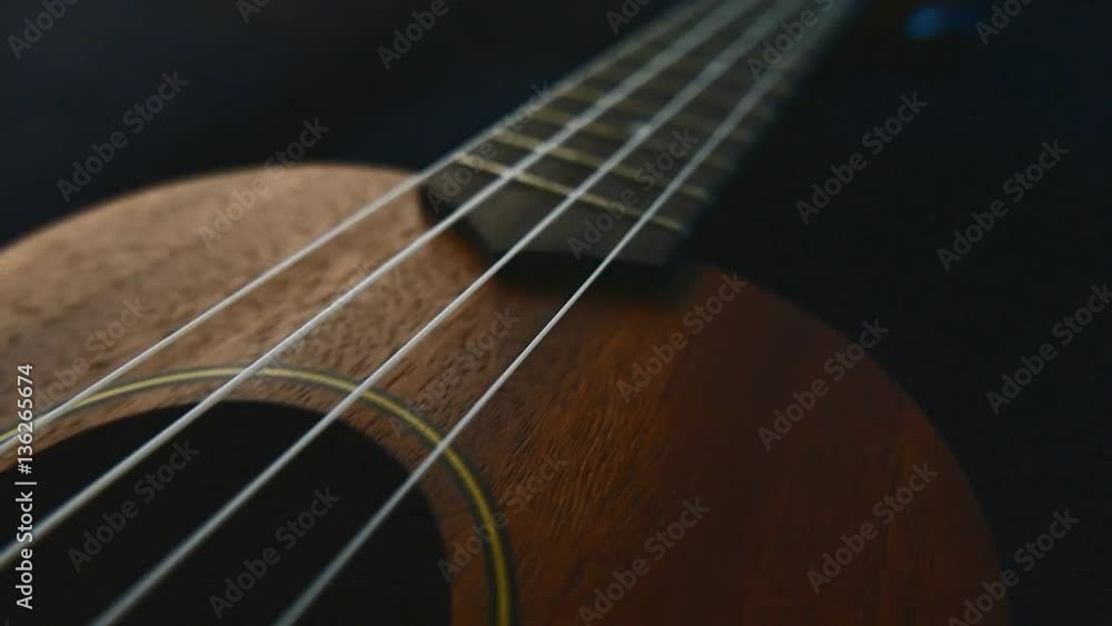 Closeup ukulele guitar tracking from camera on the slider. Closeup ukulele guitar tracking from camera on the slider.