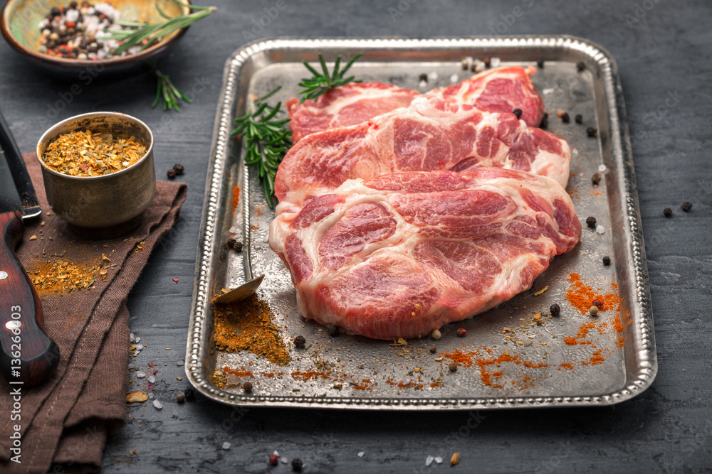 Raw pork steak for grilling on iron tray close up Raw pork steak for grilling on iron tray close up