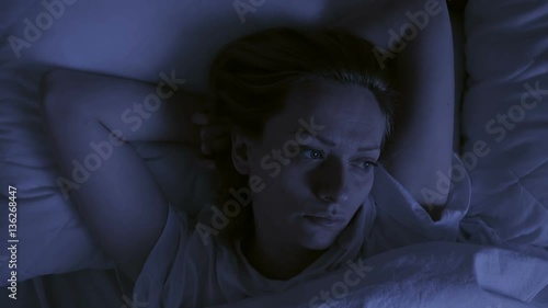 Insomnia concept. Woman in bed at night can not sleep