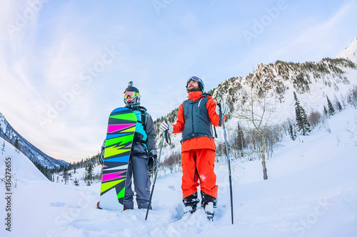 Freeriders male skiers and snowboarders are in the mountains in