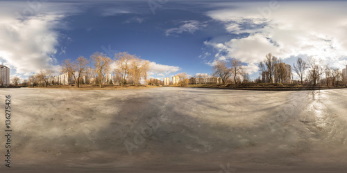 Full 360 degree equirectangula panorama on the frozen river in the city