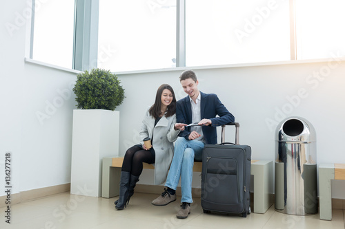 Beautiful young love hipster couple sitting at the waiting area