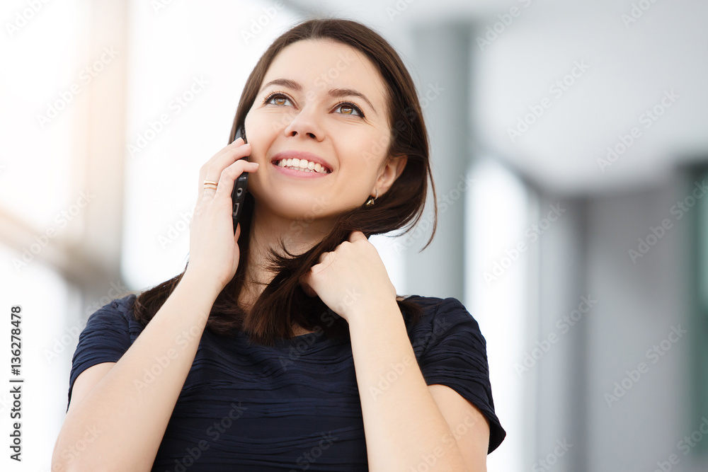 Smiling businesswoman talking on the phone at the office Smiling businesswoman talking on the phone at the office