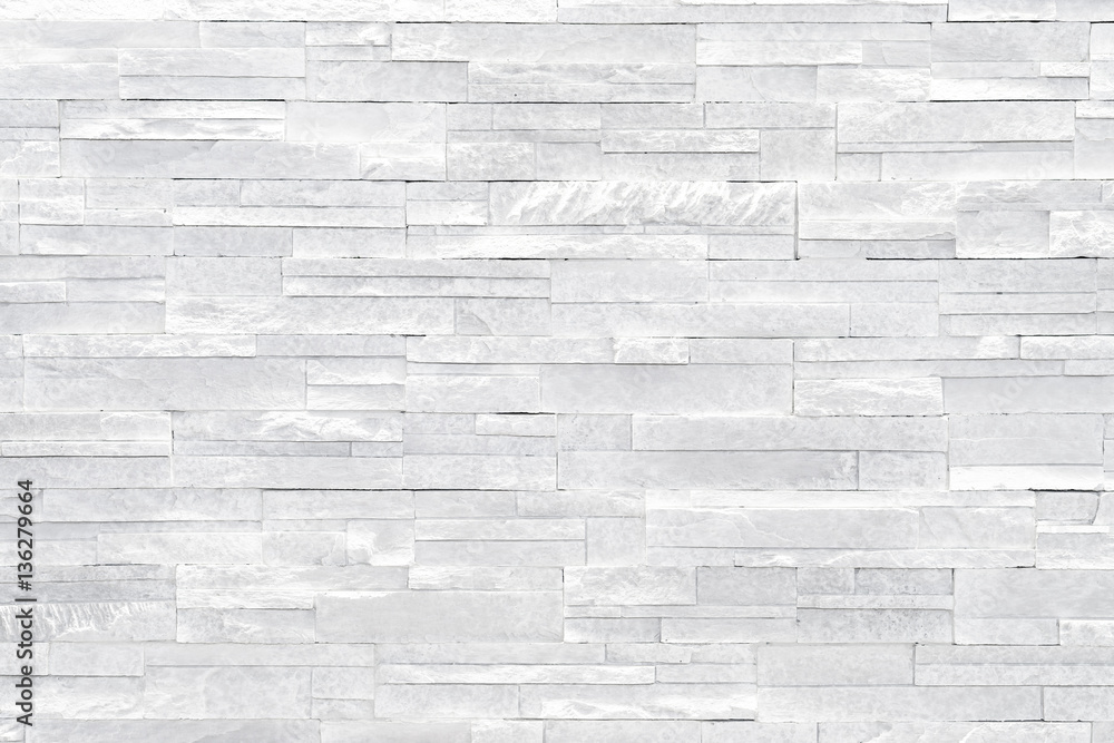 Fototapeta premium White stone wall background. Stacked stone tiles are often used in interior design decors as accent wall. Use this gray texture in graphic design to create a wallpaper, background, backdrop and more!