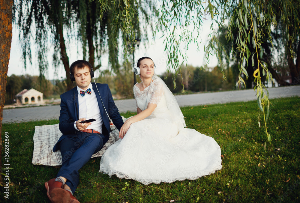 the groom and his bride seated near a large tree the groom and his bride seated near a large tree