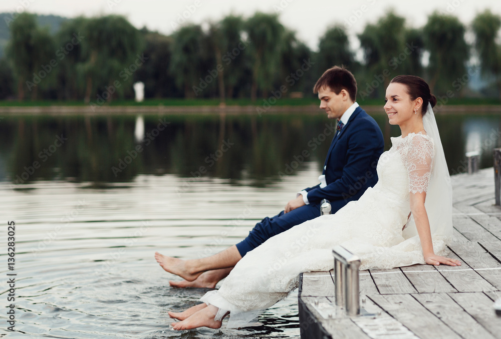 charming bride and her husband soaked feets in the lake charming bride and her husband soaked feets in the lake