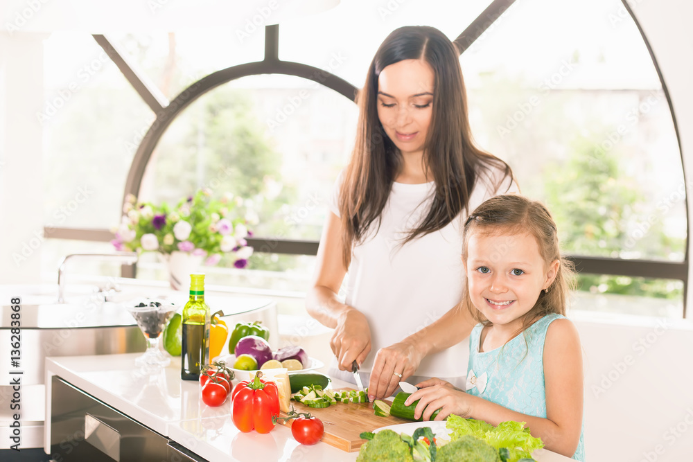 Cute little girl cooking with her mother, healthy food Cute little girl cooking with her mother, healthy food