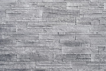 Fototapete Steine Grauer Steinmauerhintergrund. Gestapelte Steinfliesen werden häufig in Einrichtungsdekoren als Akzentwand verwendet. Verwenden Sie diese graue Textur im Grafikdesign, um ein Hintergrundbild, einen Hintergrund, einen Hintergrund und mehr zu erstellen!  © lounom