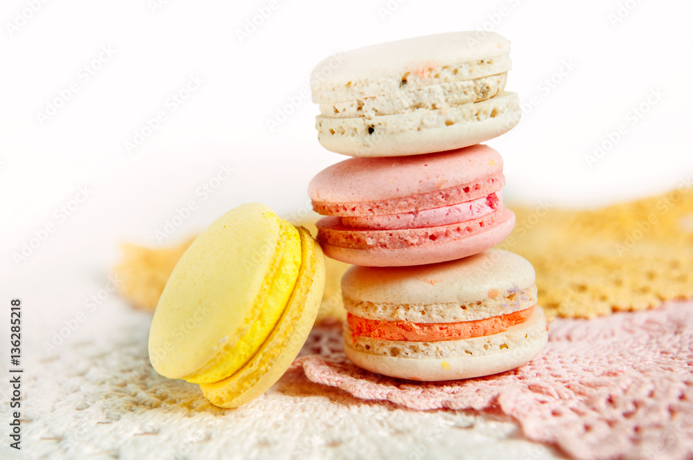 Pink, yellow and white macaroons on pastel colored lace background Pink, yellow and white macaroons on pastel colored lace background