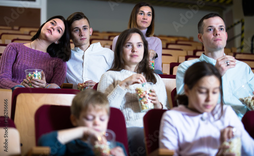 Numerous audience eating popcorn and watching a movie
