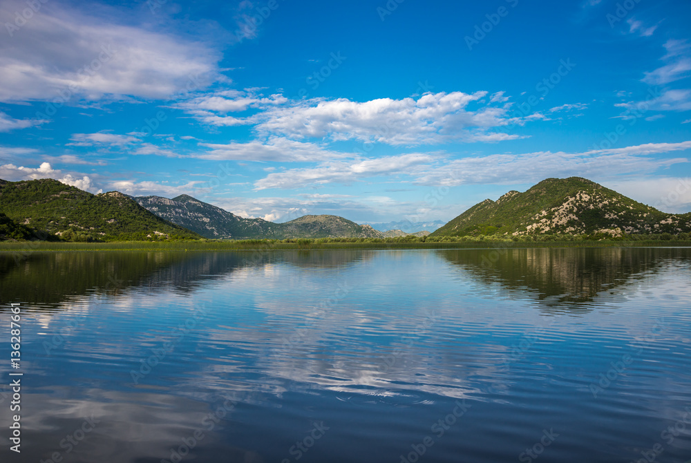 Beautiful scenery of Skadar Lake with reflection of mountains an