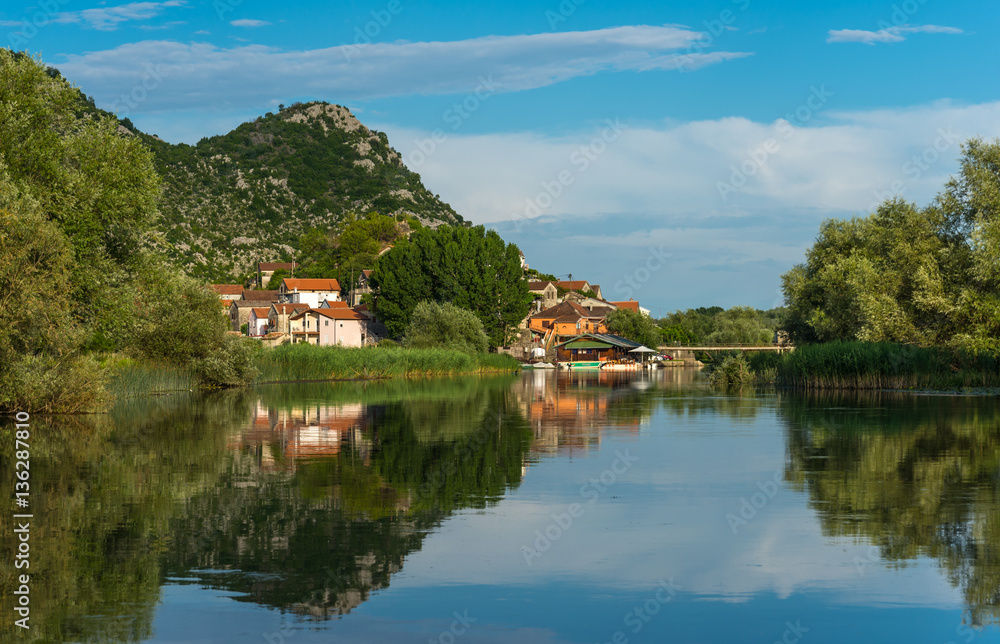 River landscape Dodosi town with reflection mountains in the ri River landscape Dodosi town with reflection mountains in the ri