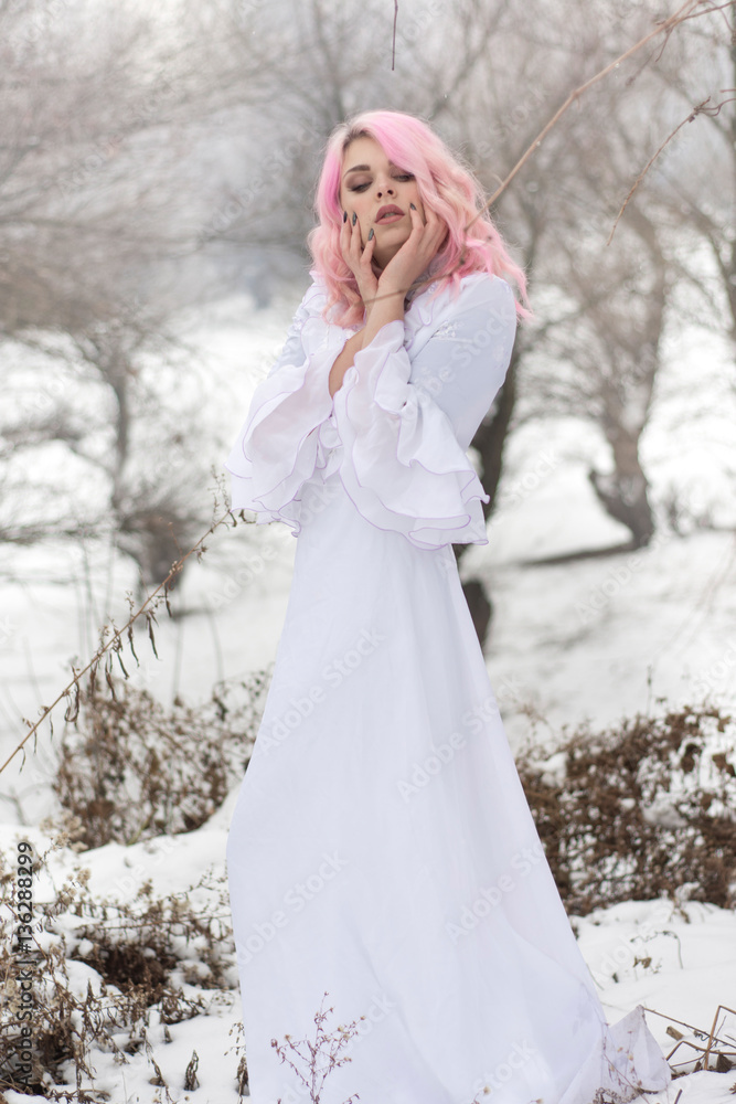 Winter portrait of a yong sensual girl in white dress at the snow forest. Winter portrait of a yong sensual girl in white dress at the snow forest.