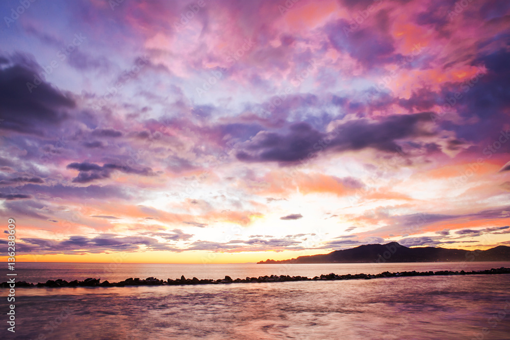 romantic sunset over sea with Portofino mount in the back